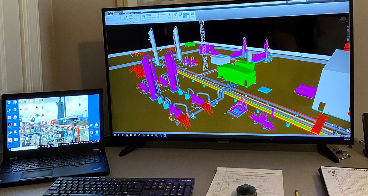 A home office station with a laptop and monitor shows a detailed rendition of pipeline equipment and operations on site.