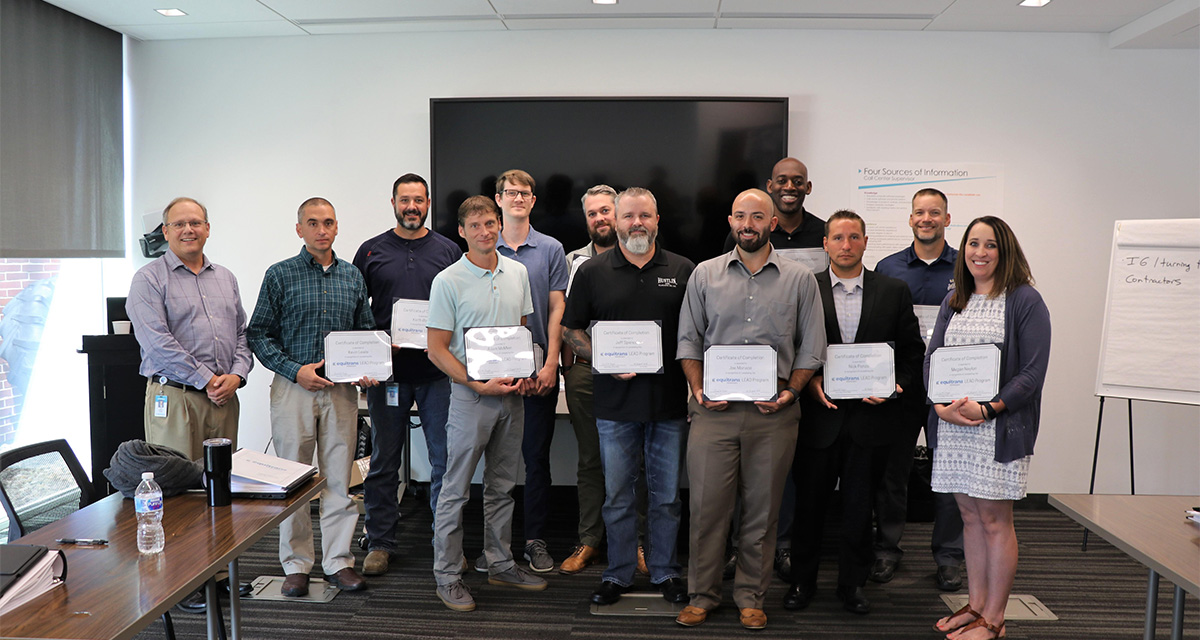 Eleven employees are being recognized and holding certificates.